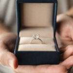 hands holding diamond ring in jewelry box